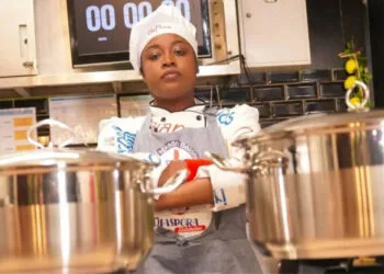 La cheffe haïtienne Leen Excellent en pleine préparation culinaire durant son marathon de 216h, symbole de la richesse gastronomique d’Haïti.
